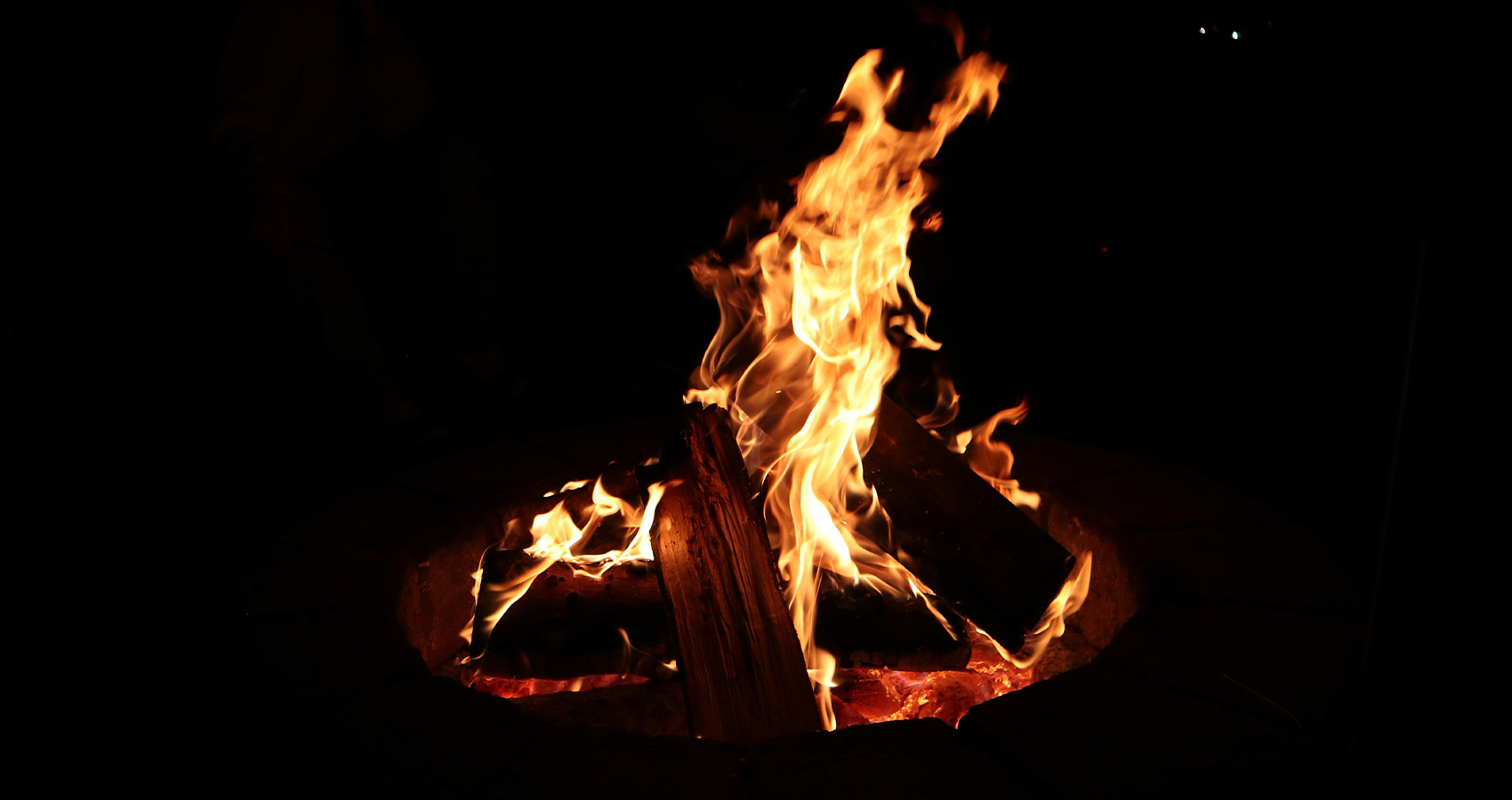 Photo of fire and wood in firepit